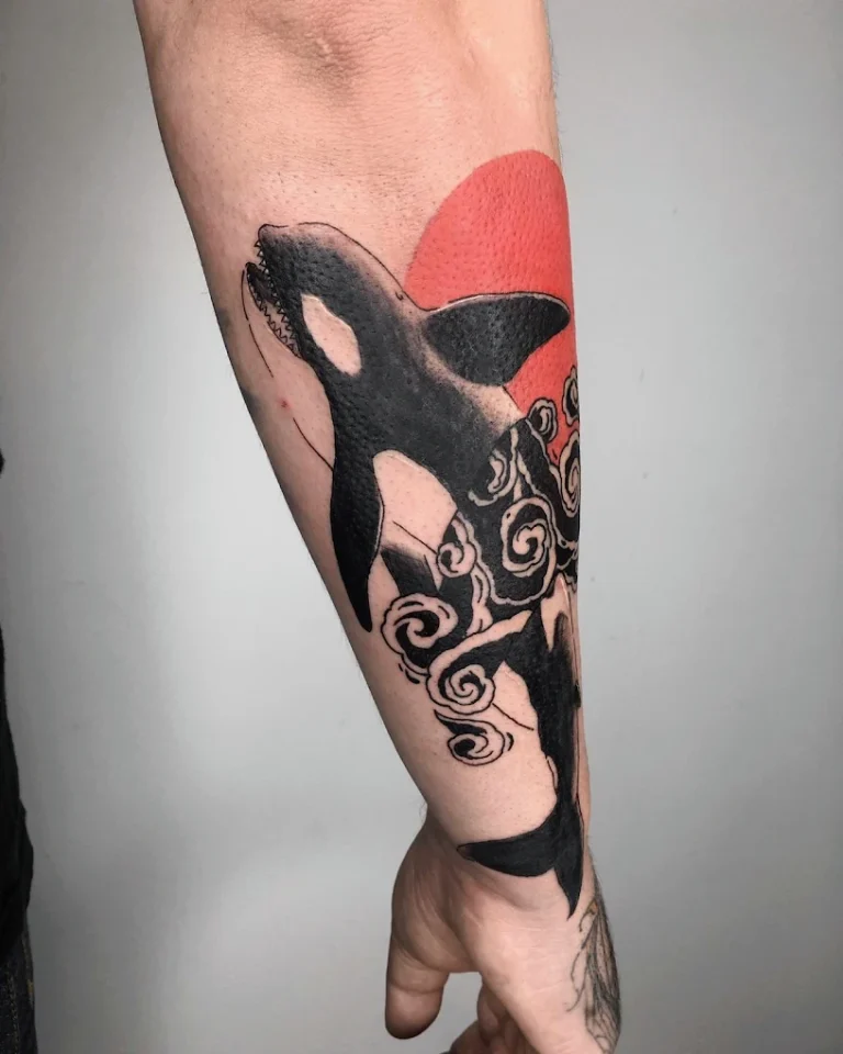 Tatuaje a color de una orca en el brazo.