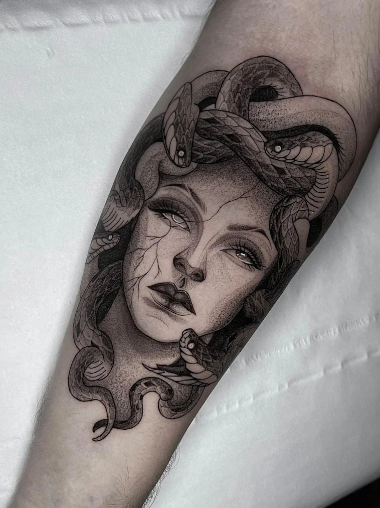 Tatuaje de Medusa en tinta negra en el brazo, estilo realista.