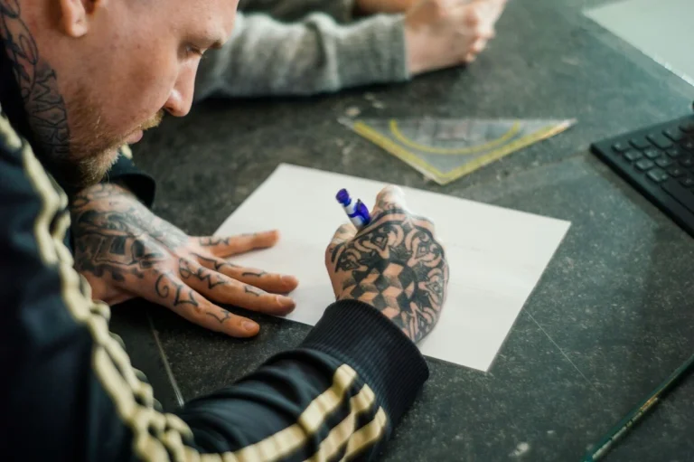Tatuador haciendo un diseño de tatuaje personalizado en papel.